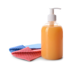 Bottle of detergent with cleaning rags on white background