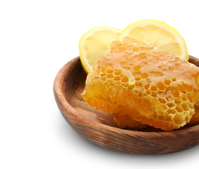 Wooden plate with honeycomb on white background