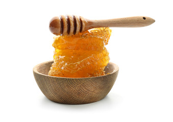 Wooden bowl with honeycomb and dipper on white background