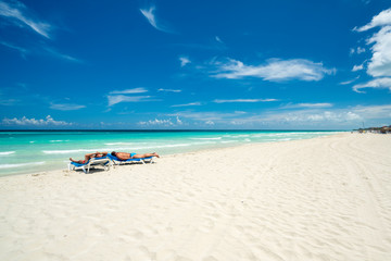 Fototapeta na wymiar Beautiful beach of Varadero during the day,two tourists lying on sea beds tan,Varadero Cuba.