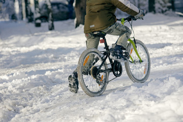 Closeup photo of guy riding bicycle on snowy background