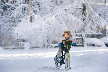 Happy young guy riding bike on fresh snow