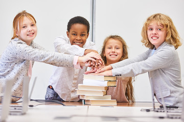 Schüler stapeln Hände für Teamwork