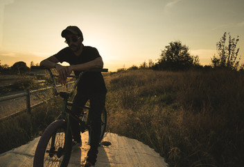 BMX rider at sunset. Guy riding a bmx bike