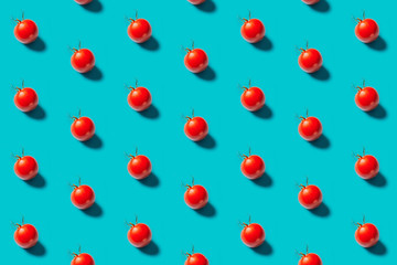 Red tomatoes pattern on a blue background, flat lay. Top view.