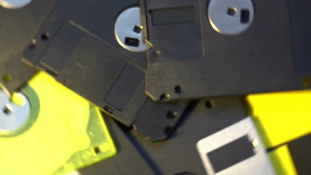 pile of old style data transfer floppy discs, rotating spinning background