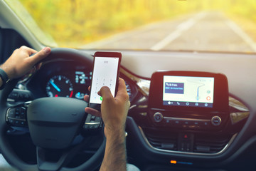 Male driver using smartphone to call 911 Emergency Number, while driving