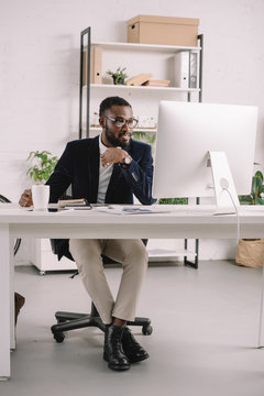 Successful African American businessman working with computer at workplace in modern office