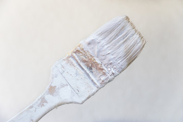 Malerpinsel mit weißer Farbe eingekleckert. Renovierungsarbeiten.