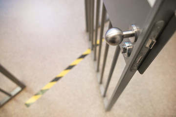 Opened jail cell door. The lock an steel bobble handle closeup . Safety line. Do not cross!