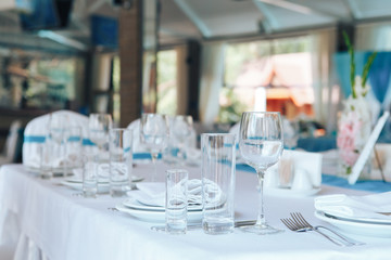 Glassware and cutlery for catered event dinner. Festive table setting in the restaurant