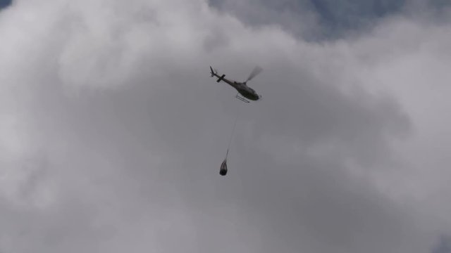 A firefighting helicopter flying in a cloudy sky