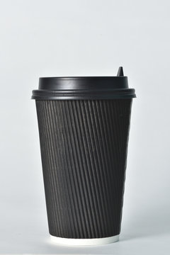 Disposable paper cup of black color on a white background. Paper cup for hot coffee. Coffee to go. Paper cup for coffee
