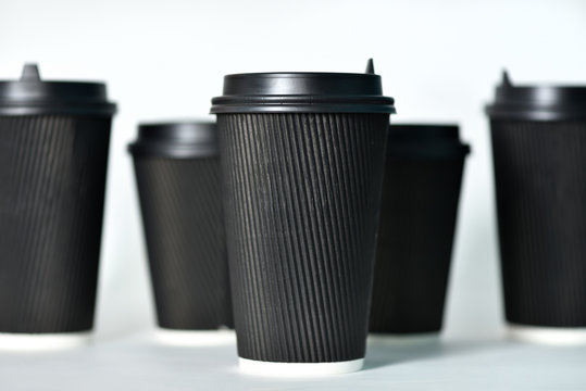 Disposable paper cups in black on a white background. Paper cups for hot coffee. Coffee to go. Paper cup for coffee