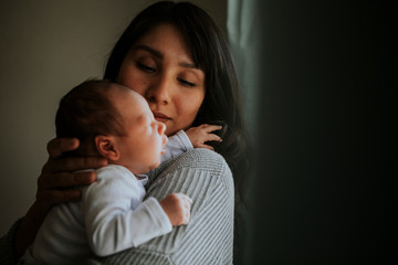 Mother holding her baby indoors © Rawpixel.com