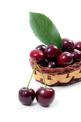 Yellow wooden basket with red sweet cherry isolated on a white background..