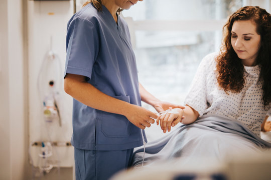 Nurse Applying An IV Drip To A Patient