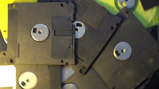 pile of old style data transfer floppy discs, rotating spinning background
