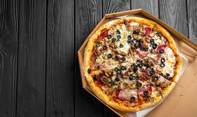 traditional italian pizza on dark black wooden board, top view, place for text