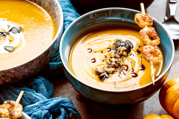 Roasted pumpkin and carrot soup with cream and pumpkin seeds 