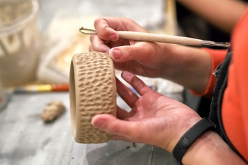 The manufacture of pottery, hands with the tool and the product