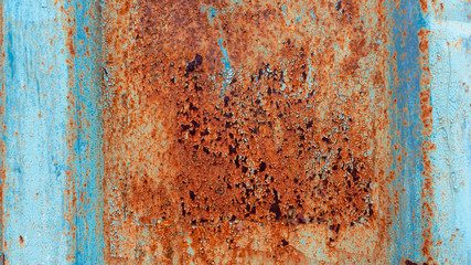 Rusty metal background with old layers of blue paint. Texture rusted shipping container.