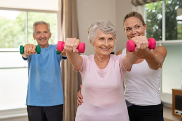 Senior couple exercising using dumbbells