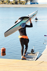Young athlete guy carries a kayak.