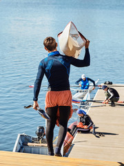 Young athlete guy carries a kayak.
