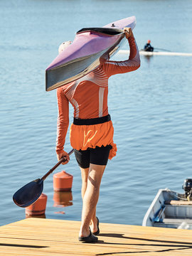 Young athlete guy carries a kayak.