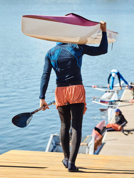Young athlete guy carries a kayak