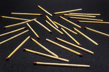Long matches lying scattered on a black background.