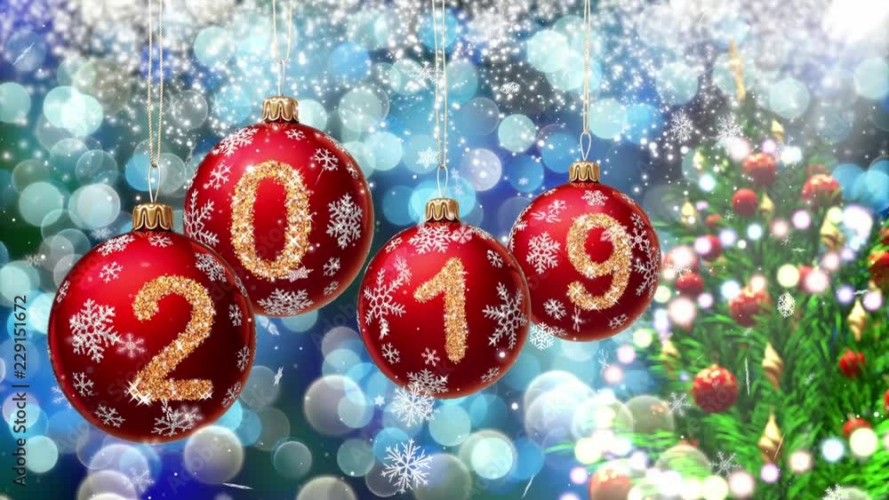 Poster red balls with numbers 2019 hanging on the background of a blue bokeh and a rotating christmas tree 