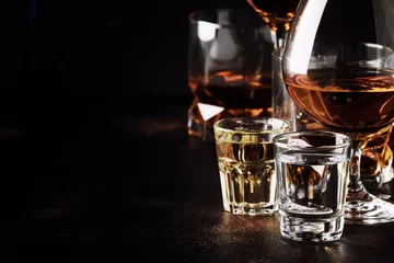 Vlies Fototapete Bar Set mit starken alkoholischen Getränken in Gläsern und Schnapsglas in verschiedenen Sorten: Wodka, Rum, Cognac, Tequila, Brandy und Whisky. Dunkler Vintage-Hintergrund, selektiver Fokus