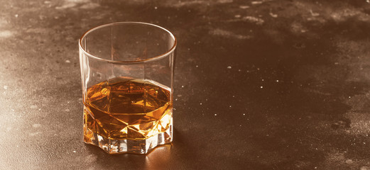 Bourbon in glass, american corn whiskey, dark bar counter, selective focus