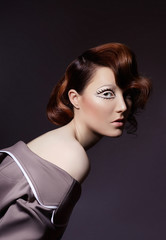 Naklejka premium Portrait of a woman with bright colored flying hair, all shades of brown. Hair coloring, beautiful lips and makeup. Hair fluttering in the wind. Sexy girl with short hair. Professional coloring