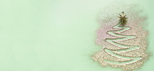 Christmas tree made of glitter on blue background. Winter, new year concept. Flat lay, top view. Shiny greeting card with copy space. Banner