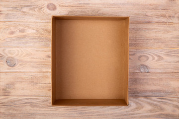 Opened cardboard box on wooden background. top view