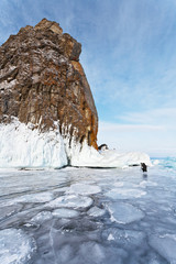 Baikal Lake. Tourist photographs a famous natural landmark Virgin Rock (Deva Rock) at the northern Cape Khoboy of Olkhon Island