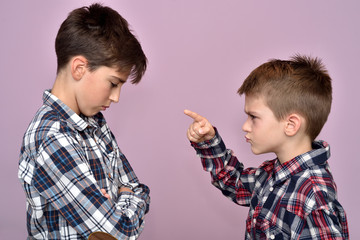 Angry young boy with index fingers up scolding a scared older brother