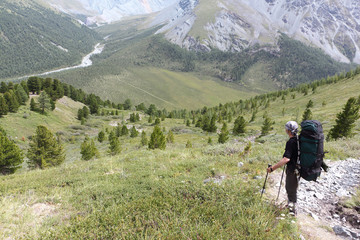 Fototapeta na wymiar Man with a backpack standing on the pass Kara-Turek, view of the Jarlu River valley
