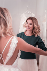Happy motherhood. Joyful good looking woman supporting her daughter while being with her in the beauty salon