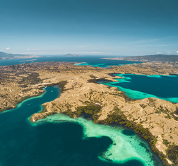 Bays, savanna lands, ocean. Komodo. Aerial shot. Spectacular panoramic view from above the stunning bays and savanna territory of Komodo National Park. Indonesia. Heritage Site. Overview drone shot.