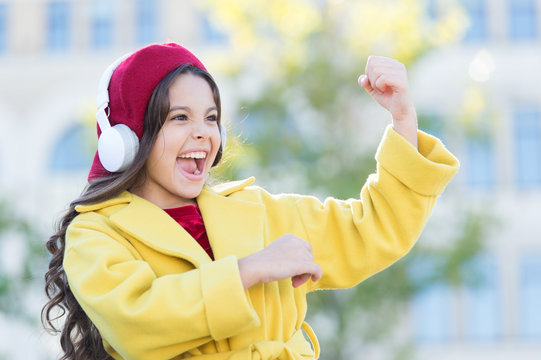 Positive influence of music. Child girl french style outfit enjoying music. Childhood and teenage music taste. Little girl listening music enjoy favorite song. Girl with headphones urban background
