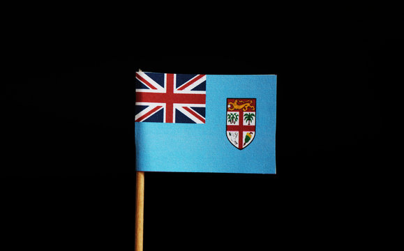 A paper Flag of Fiji on wooden stick on black background. Fiji is island state. Fiji belongs to Oceania - Powered by Adobe