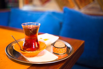 Turkish tea in traditional glass on tray closeup. Istanbul cafe with oriental culture of the street food.