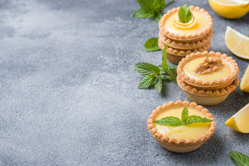 Homemade lemon curd in tartlets with fresh lemon and mint leaves. Copy space