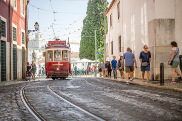 Red tram on historic streets of Lisbon, capital city of Portugal
