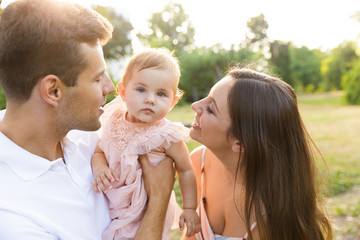 Positive young family with little baby girl spending time together