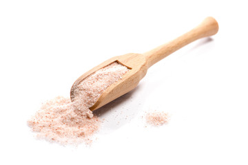 Close-up of pile of ground rose himalayan salt spice in a wooden spoon on white background